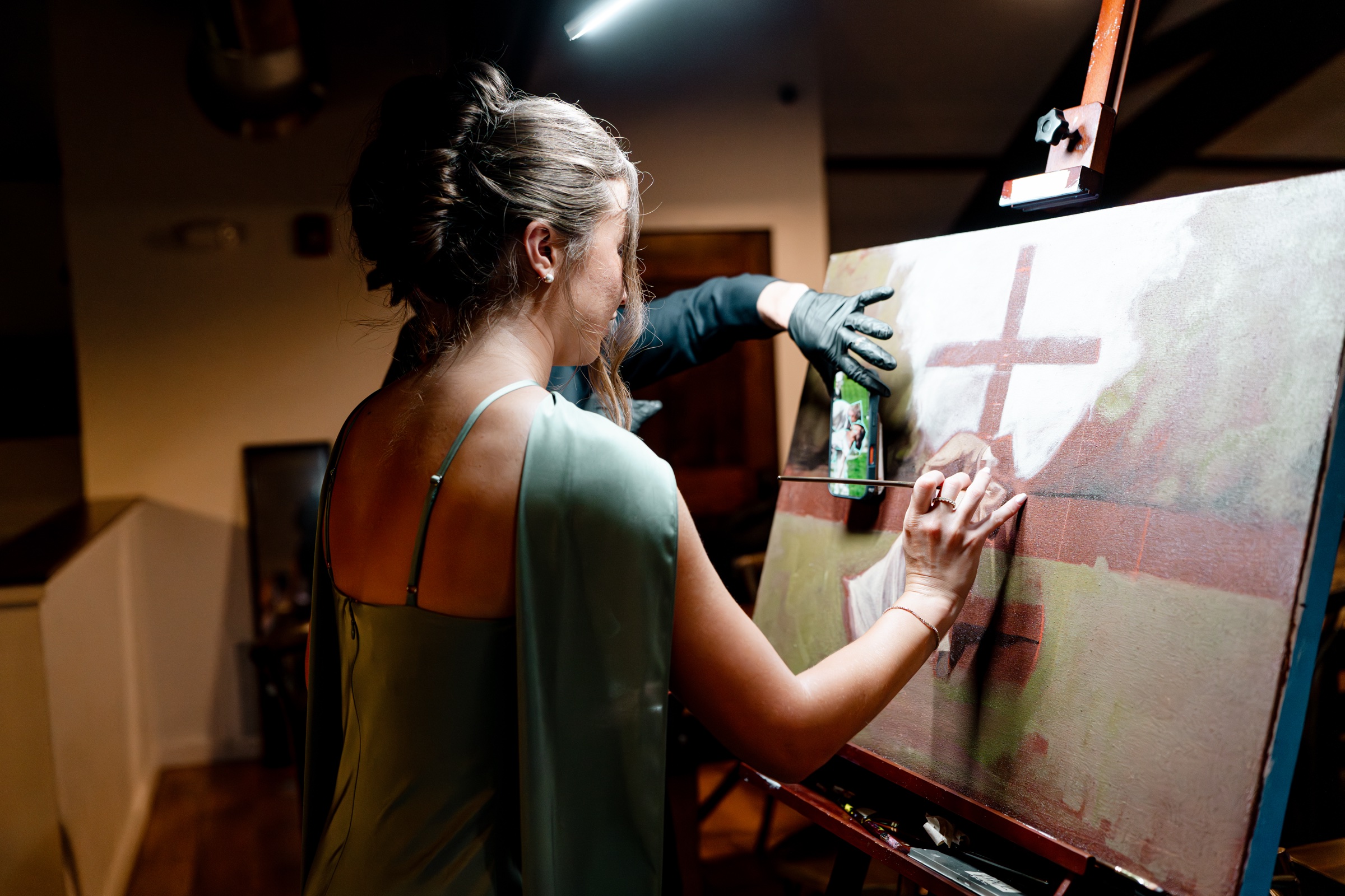 A wedding guest adding a brushstroke to the live painting.